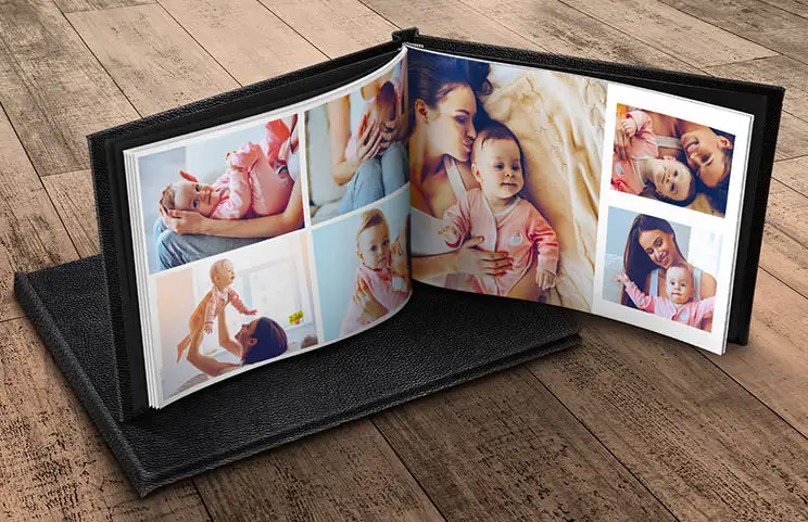 Custom made photo album open on table with photo collage of family photos