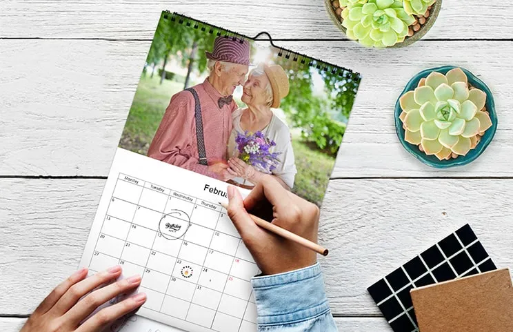 Woman writing on A4 customised wall calendar by printerpix with christmas theme photo