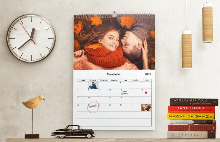 Romantic couple in living room with personalised 2020 wall calendar with proposal photo