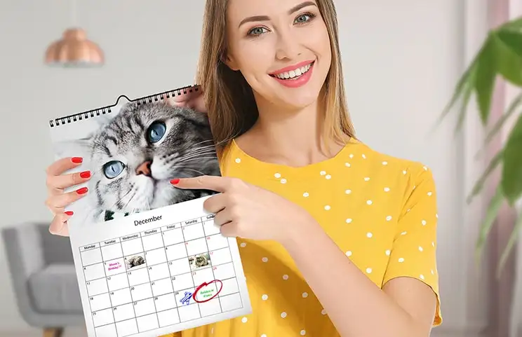 Dog photos on custom design photo calendar hung up on wall